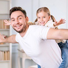 Man giving his daughter a piggy back ride