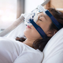 Woman sleeping with CPAP mask