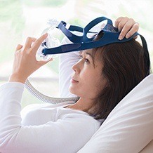 Woman placing CPAP mask