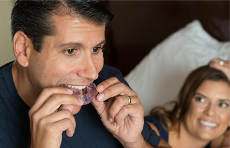 Man placing custom sleep apnea appliance