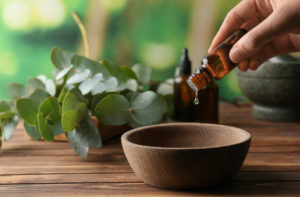 Hand adding drops of essential oil to a bowl