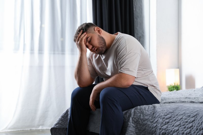 Depressed man sitting on a bed